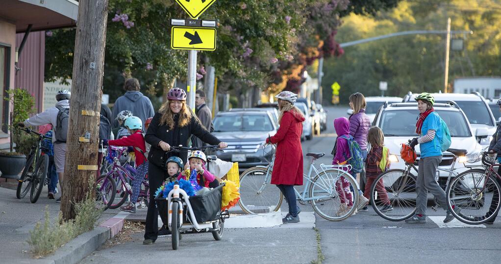 Bikers, walkers and skaters use the crosswalk across 4th St. in Santa Rosa on their way to Proctor Terrace Elementary School on International Walk and Roll to School Day on Wednesday morning. (photo by John Burgess/The Press Democrat)