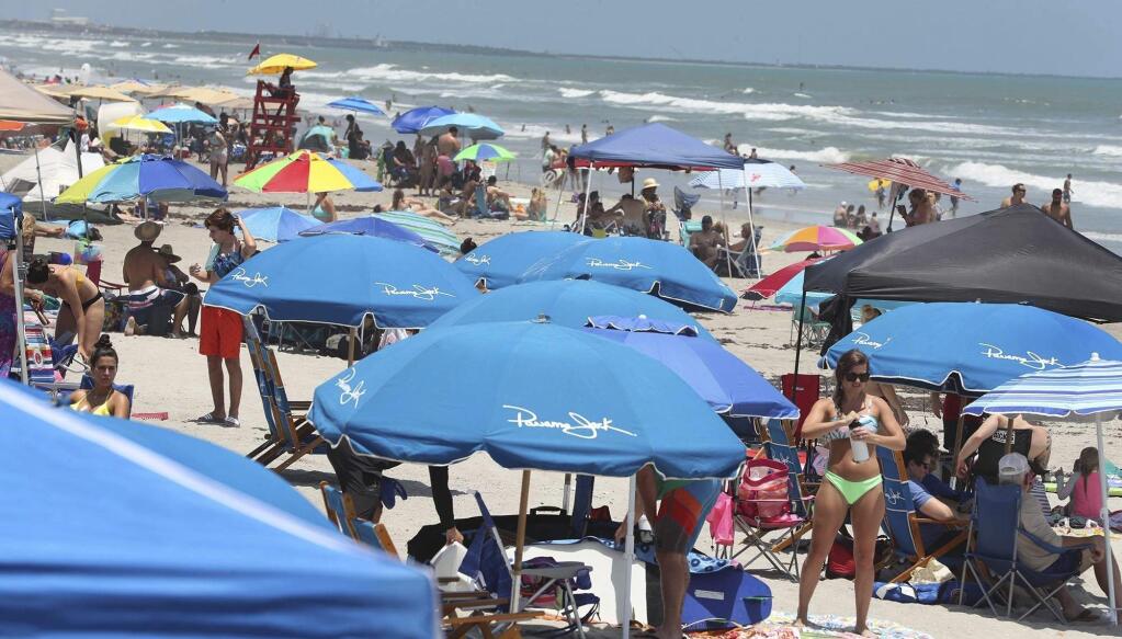Cocoa Beach, Fla., is packed with Memorial Day beachgoers on Saturday, May 23, 202 The beaches are open for business again during the coronavirus epidemic. (Stephen M. Dowell/Orlando Sentinel via AP)