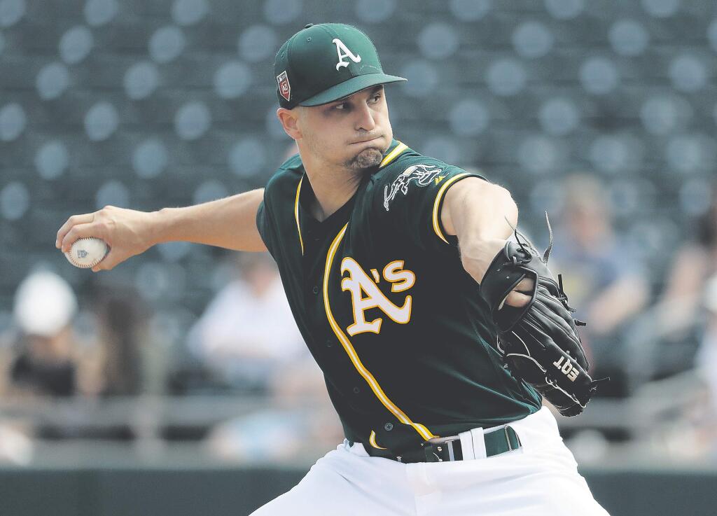 Oakland Athletics starting pitcher Kendall Graveman throws against the Los Angeles Angels during the first inning of a spring baseball game in Mesa, Ariz., Thursday, March 8, 2018. (AP Photo/Chris Carlson)
