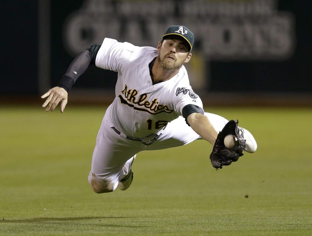 Oakland Athletics right fielder Josh Reddick makes the catch on a ball hit Tampa Bay Rays' Evan Longoria, before losing it when he made contact with the field in the fifth inning of a baseball game Tuesday, Aug. 5, 2014, in Oakland, Calif. Longoria singled on the play. (AP Photo/Ben Margot)