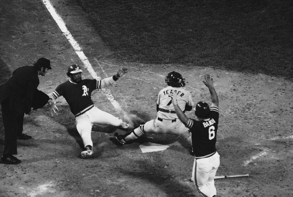 Umpire Don Denkinger, left, keeps an eye on a sliding Reggie Jackson as Dodger catcher Steve Yeager takes the throw in sixth inning of World Series Game 4 at the Oakland Coliseum, Wednesday, Oct. 17, 1974. (AP Photo)