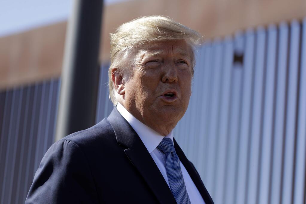 President Donald Trump talks with reporters as he tours a section of the southern border wall, Wednesday, Sept. 18, 2019, in Otay Mesa, Calif. (AP Photo/Evan Vucci)