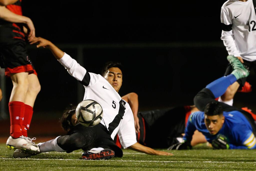 Santa Rosa's Edwin Martinez (5), a first-team all-league selection, slides to clear the ball away from the goal during the second half of the NCS Division 1 semifinal boys soccer match between Monte Vista and the host Panthers on Feb. 24. (Alvin Jornada / The Press Democrat)