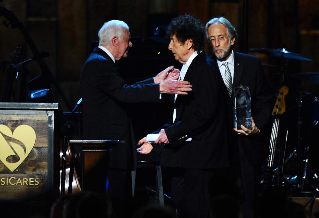 FILE - In this Feb. 6, 2015, file photo, President Jimmy Carter, left, presents Bob Dylan with the award for 2015 MusiCares Person of the Year at the 2015 MusiCares Person of the Year show at the Los Angeles Convention Center in Los Angeles. Dylan won the 2016 Nobel Prize in literature on Thursday, Oct. 13, 2016, a stunning announcement that for the first time bestowed the prestigious award on a musician for 'having created new poetic expressions within the great American song tradition.' (Photo by Vince Bucci/Invision/AP, File)