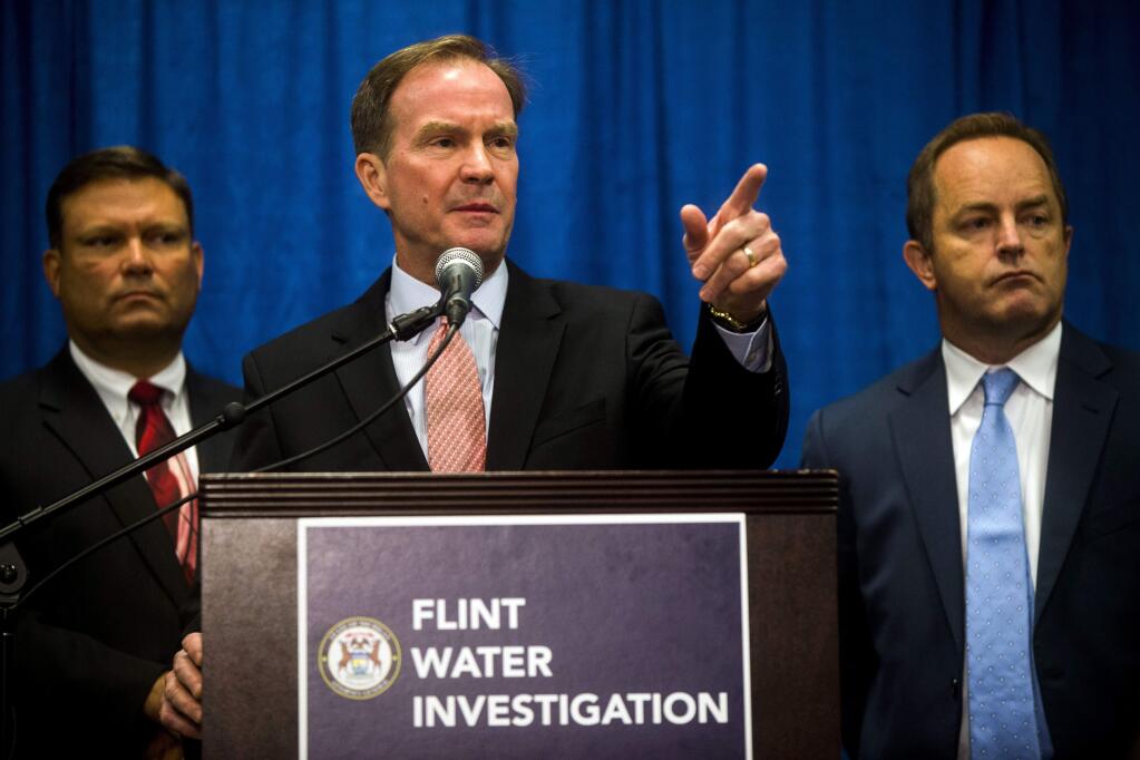 Attorney General Bill Schuette announces six more state employees are charged in connection to the Flint water crisis on Friday, July 29, 2016 at University of Michigan-Flint in downtown Flint. (Jake May/The Flint Journal-MLive.com via AP)