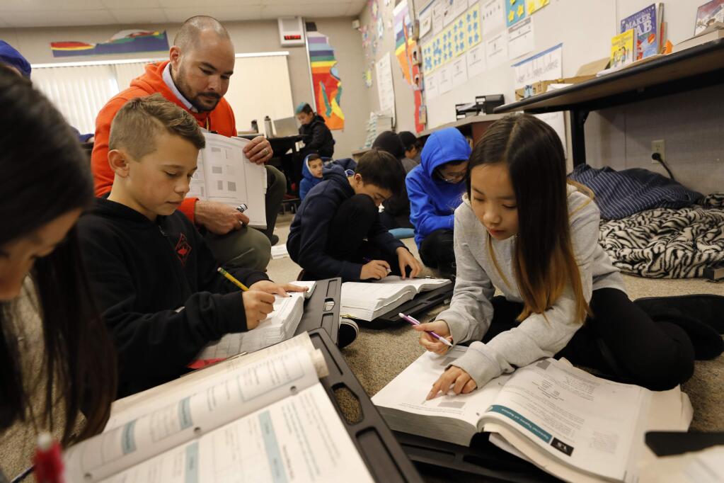 Sixth grade students Kim Vu, 11, right, and Nathan Romero, 11, work with teacher James Showalter-Garcia on percentages during a math lesson at Schaefer Elementary School in Santa Rosa, California on Wednesday, February 13, 2019 . (BETH SCHLANKER/The Press Democrat)