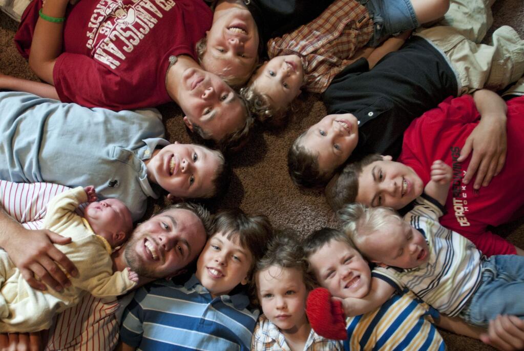 In this Aug. 6, 2013 file photo, the 12 Schwandt brothers pose for a photo in their home in Rockford, Mich. Clockwise from bottom left are, Tyler, 21, holding Tucker, 2 days, Vinny, 10, Drew, 16, Zach, 17, Charlie, 3, Calvin, 8, Brandon, 14, Luke, 19 months, Gabe, 6, Wesley, 5 and Tommy, 11. Jay and Kateri Schwandt, a western Michigan couple with 12 sons is expecting baby No. 13 and they say they'll be surprised if their all-boy streak is snapped. The Grand Rapids Press reports that Schwandt's baby is due May 9, 2015 and they plan to follow their tradition of not finding out whether it's a boy or girl in advance. (AP Photo/MLive.com, The Grand Rapids Press, Chris Clark, File)