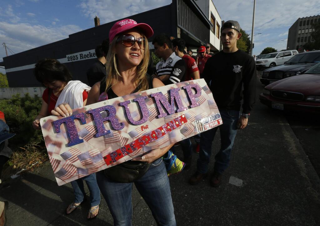 Marcyann Ritchie, of Snhomish, Wash., holds her homemade sign supporting Republican presidential candidate Donald Trump as she waits in line Tuesday, Aug. 30, 2016, for a Trump rally in Everett, Wash. (AP Photo/Ted S. Warren)