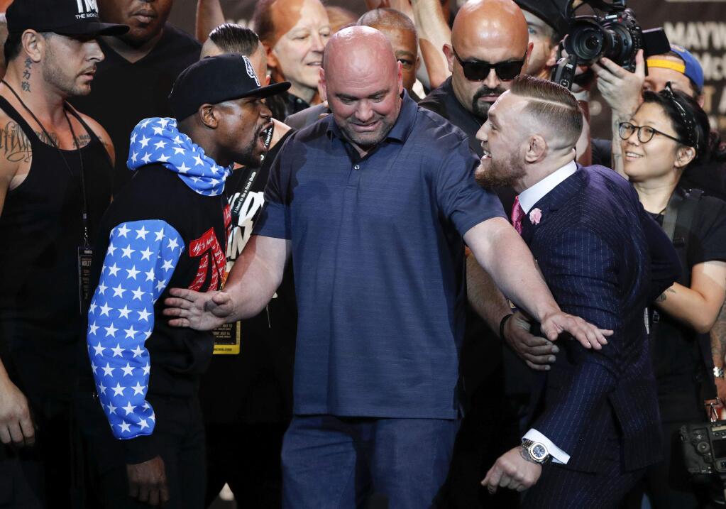 UFC president Dana White, center, intervenes as boxer Floyd Mayweather Jr., left, and mixed martial arts fighter Conor McGregor exchange words during a news conference at Staples Center Tuesday, July 11, 2017, in Los Angeles. The two are scheduled to fight in a boxing match in Las Vegas on Aug. 26. (AP Photo/Jae C. Hong)