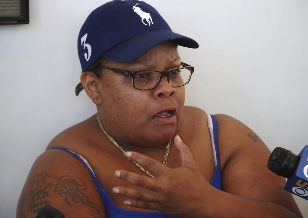 Alicia Grayson, mother of Nia Wilson who was fatally stabbed at a BART Station, gestures while speaking to reporters Wednesday, July 25, 2018, while waiting to enter a courtroom in Oakland, Calif. A paroled robber who allegedly stabbed Nia Wilson to death and wounded her sister in an unprovoked attack at a California train station was charged with murder and attempted murder on Wednesday. John Cowell, 27, was set to be arraigned in Oakland in the attack against Nia Wilson, 18, of Oakland, and her 26-year-old sister, Letifah Wilson. (AP Photo/Ben Margot)