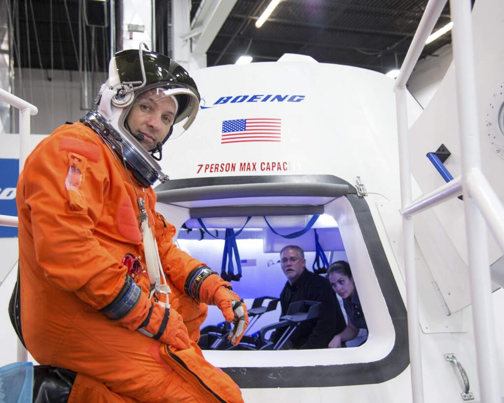 In this undated image provided by NASA, astronaut Randy Bresnik prepares to enter The Boeing Company's CST-100 spacecraft for a fit check evaluation at the company's Houston Product Support Center. (AP Photo/NASA)