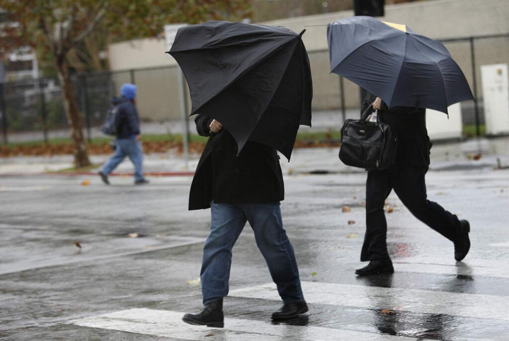 Farheen Sultana fights the wind and rain at Fifth and Santa Clara streets in San Jose, Calif., on Monday, Dec. 15, 2014. (AP Photo/San Jose Mercury News, Gary Reyes)