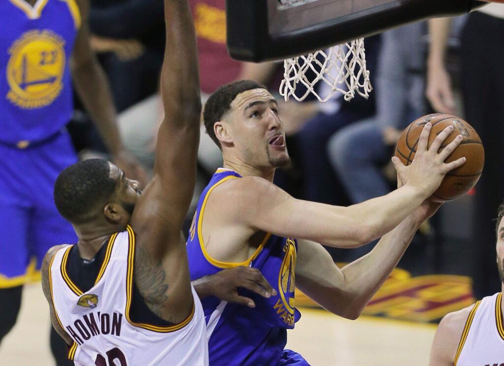 Golden State Warriors guard Klay Thompson scores against Cleveland Cavaliers center Tristan Thompson and forward Kevin Love during Game 3 of the NBA Finals in Cleveland on Wednesday, June 7, 2017. The Warriors defeated the Cavaliers 118-113. (Christopher Chung / The Press Democrat)