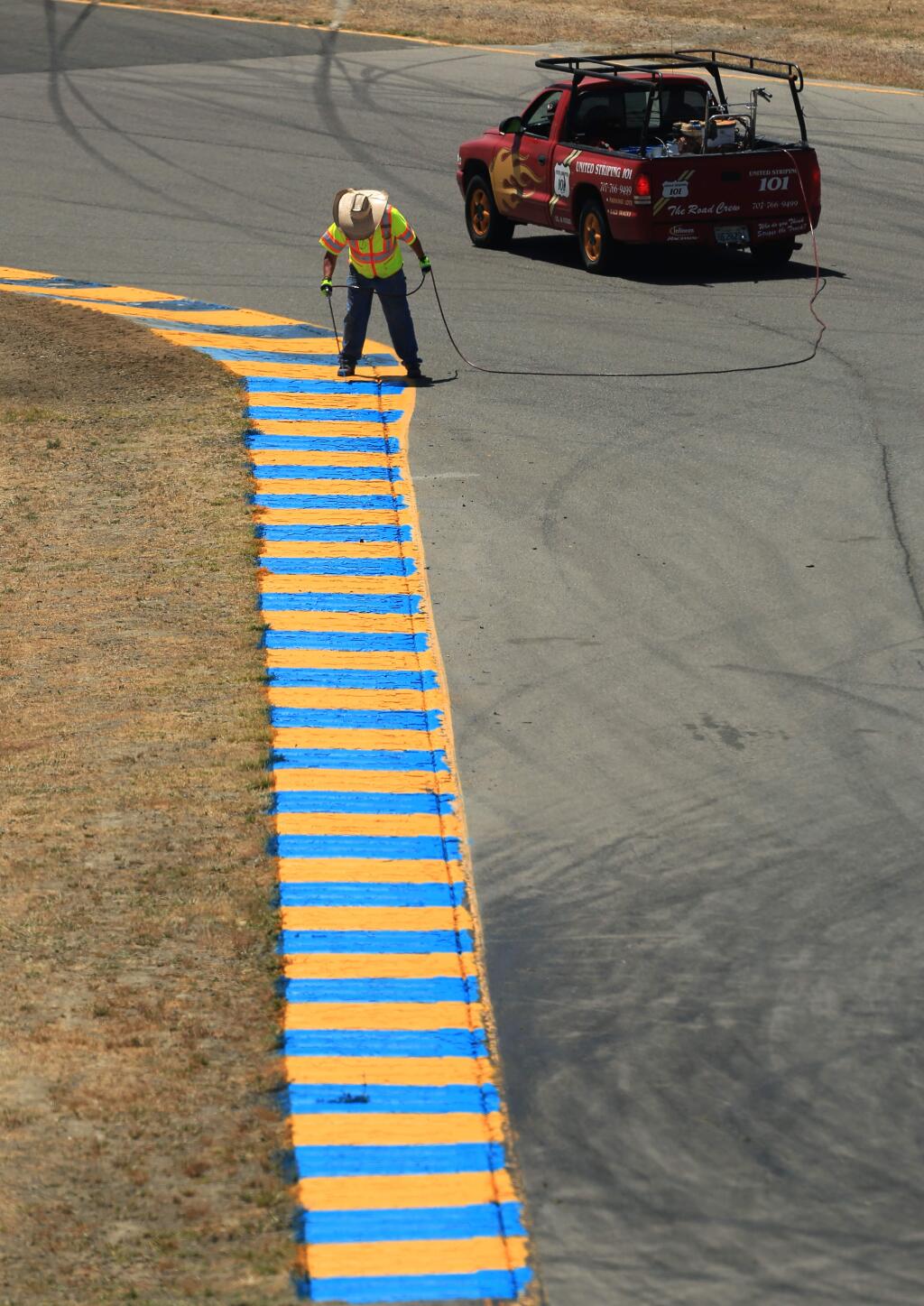 A rumble strip is touched up by an employee of 101 Striping on turn 7 Sonoma Raceway,Wednesday June 25, 2015 in Sonoma in preparation for NASCAR events this weekend . (Kent Porter / Press Democrat) 2015
