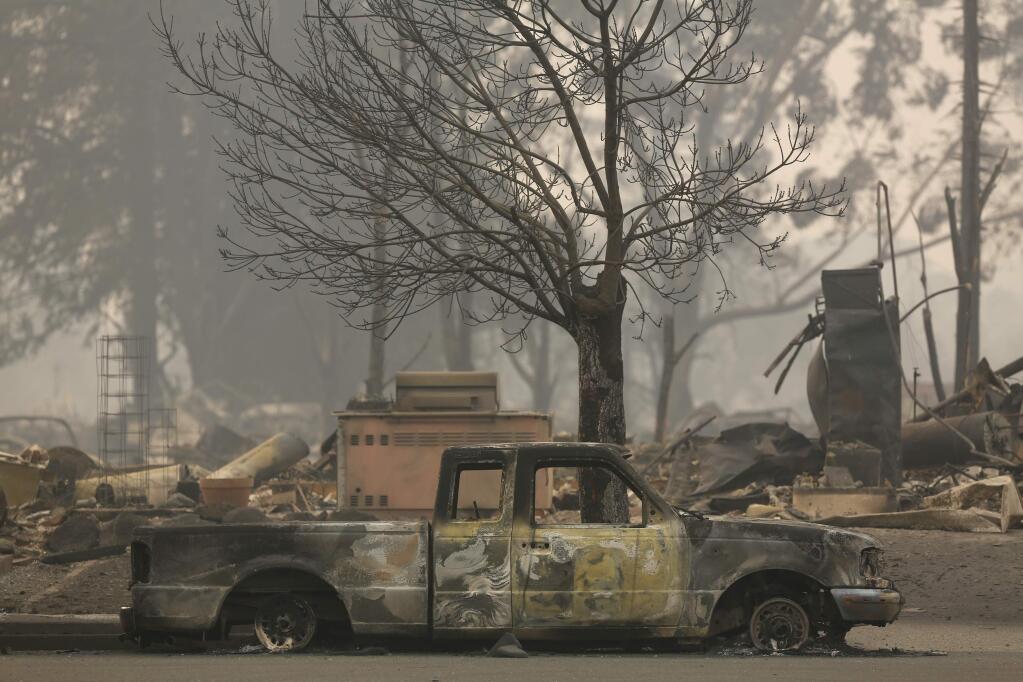 A burned truck sits in front of a home that destroyed by the fire in the Coffey Park area of Santa Rosa, on Tuesday, October 10, 2017. (BETH SCHLANKER/ The Press Democrat)