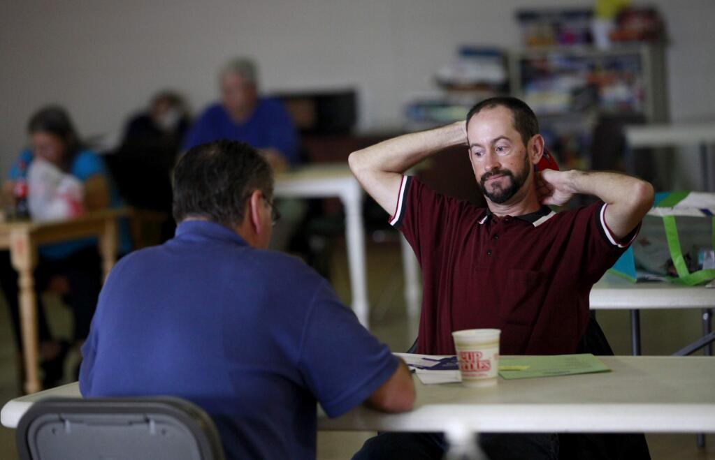 Matthew Aten, right, talks with Charles Wallace about looking for a job as they share their days activities with each other in the gymnasium at Sam Jones Hall in Santa Rosa, California on Monday, November 3, 2014. (BETH SCHLANKER/ The Press Democrat)