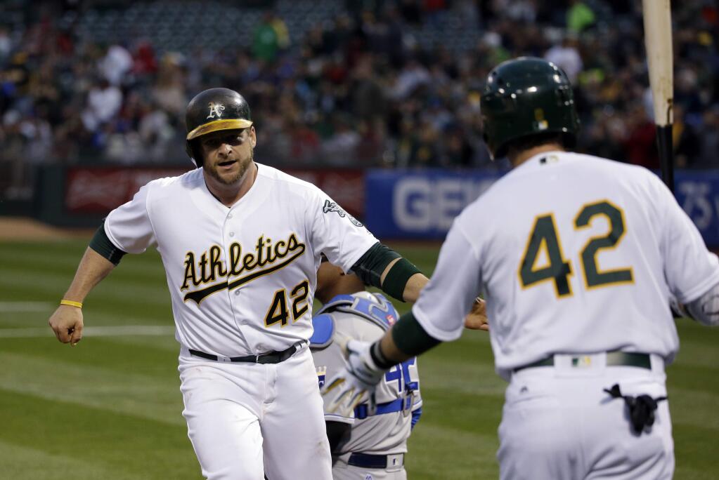 Oakland Athletics' Stephen Vogt, left, is met at the plate by teammate Jed Lowrie after Vogt's solo home run against the Kansas City Royals during the second inning Friday, April 15, 2016, in Oakland. (AP Photo/Marcio Jose Sanchez)