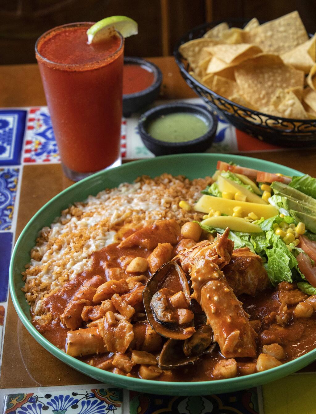 Mariscos Jarochos of prawns, octopus, scallops, crab legs, fish and green mussels in red sauce with a Michelada spiced beer from the La Hacienda Mexican Grill in Sonoma. (John Burgess/The Press Democrat)