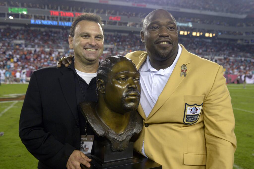 Former Tampa Bay Buccaneers defensive lineman Warren Sapp poses with sports agent Drew Rosenhaus after being inducted into the team's Ring of Honor during a halftime ceremony Nov. 11, 2013. (AP Photo/Phelan M. Ebenhack)