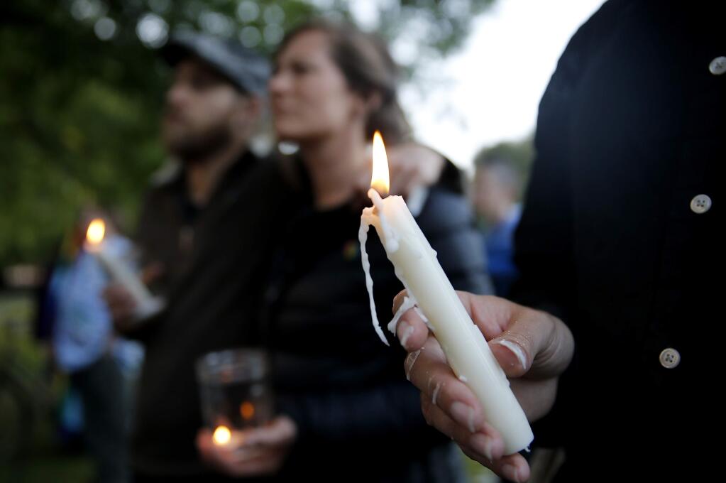 People light candles during a vigil to remember victims of the Orlando shooting at Juilliard Park in Santa Rosa, on Sunday, June 12, 2016. (BETH SCHLANKER/ The Press Democrat)