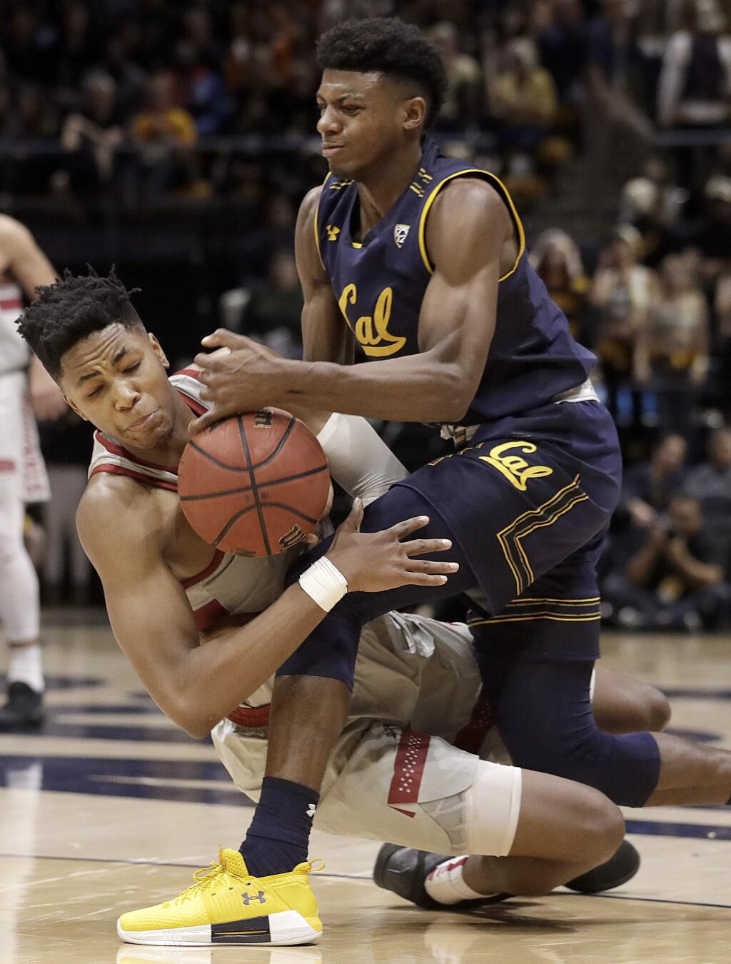 California guard Darius McNeill, top, and Stanford forward KZ Okpala fight for the ball during the first half of an NCAA college basketball game in Berkeley, Sunday, Feb. 18, 2018. (AP Photo/Jeff Chiu)