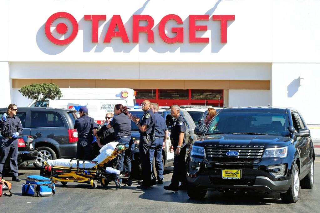 Police and medical personnel stand by in the parking lot in front of a Target store after a fatal shooting in Sand City, Calif., Monday, Sept. 21, 2015. (Nic Coury/Monterey County Weekly via AP)