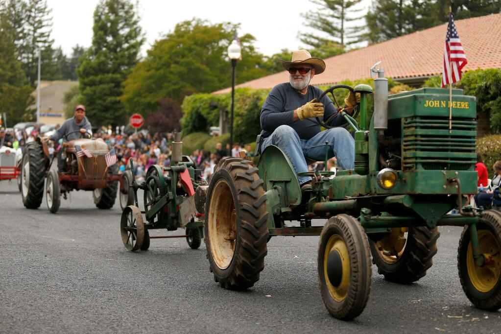 Terry Wilson of the Early Day Gas Engine and Tractor Association leads a caravan of classic farm tractors during the Healdsburg Future Farmers Country Fair's Twilight Parade, in Healdsburg, California, on Thursday, May 25, 2017. (Alvin Jornada / The Press Democrat)