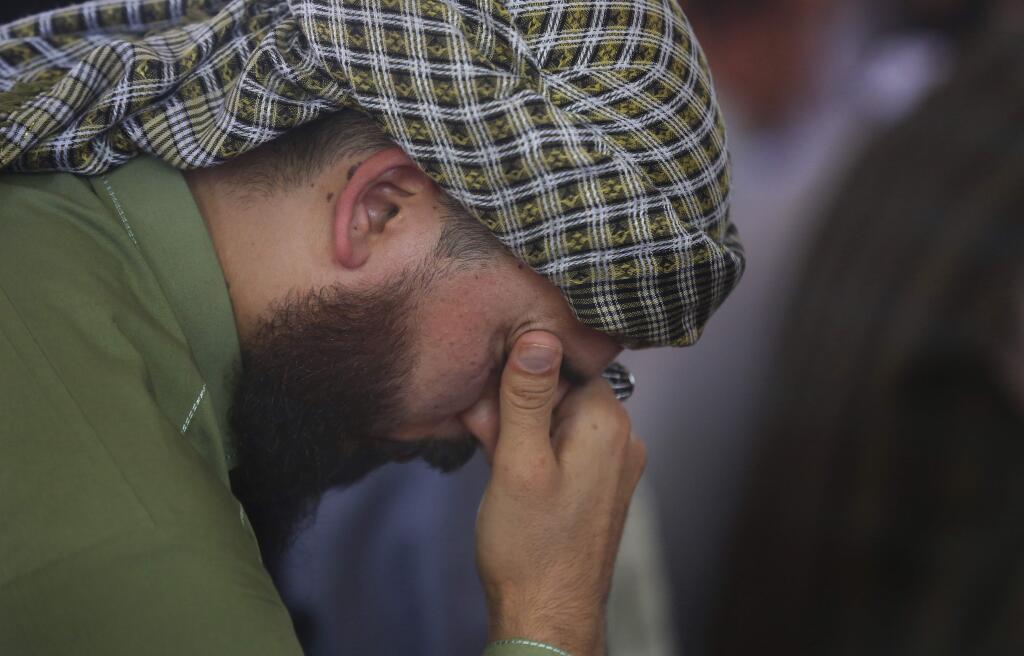 A man mourns for victims of the Dubai City wedding hall bombing during a memorial service at a mosque in Kabul, Afghanistan, Tuesday, Aug. 20, 2019. Hundreds of people have gathered in mosques in Afghanistan's capital for memorials for scores of people killed in a horrific suicide bombing at a Kabul wedding over the weekend. (AP Photo/Rafiq Maqbool)