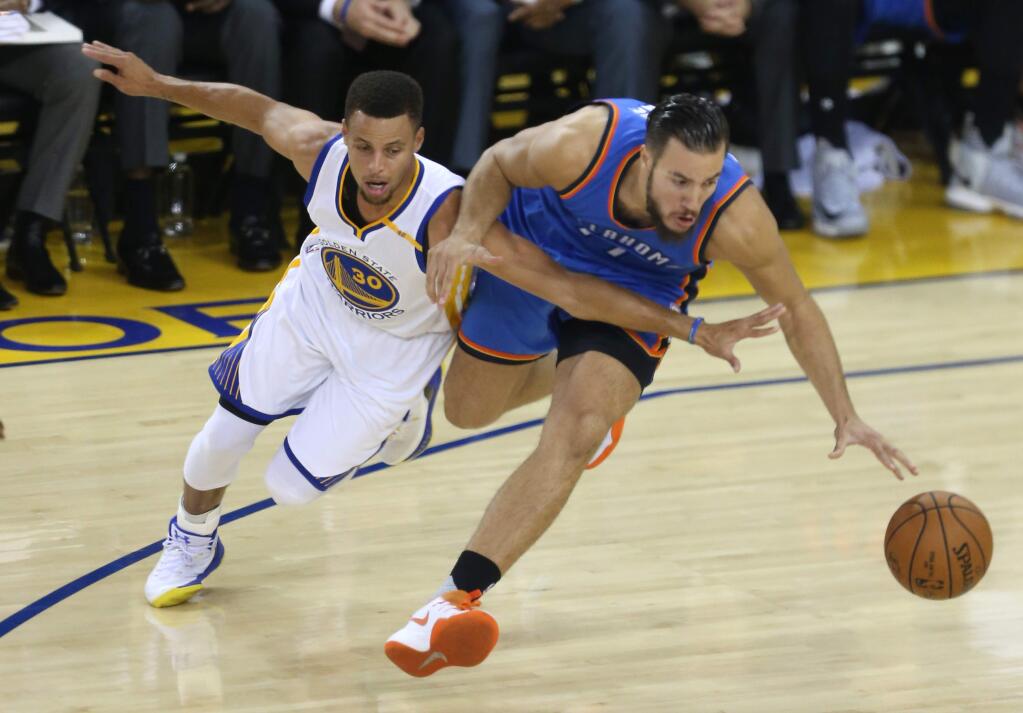 Golden State Warriors guard Stephen Curry tries to steal the ball from Oklahoma City Thunder forward Joffrey Lauvergne, during their game in Oakland on Thursday, November 3, 2016. (Christopher Chung/ The Press Democrat)
