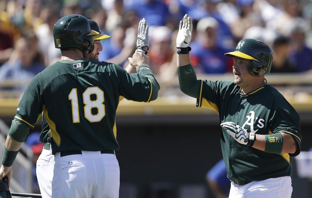 Oakland Athletics' Billy Butler, right, is congratulated by Ben Zobrist (18) after Butler hit a two run home run off Chicago Cubs' Edwin Jackson in the first inning of a spring training exhibition baseball game Tuesday, March 24, 2015, in Mesa, Ariz. (AP Photo/Ben Margot)