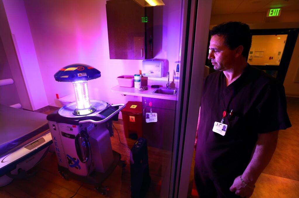 Sonoma Valley hospital environmental specialist Juan Sicairos watches as the Xenex disinfection machine emits a full spectrum ultraviolet light in an emergency room bay. The pulses of light kill common bacteria in the air and on surfaces. (JOHN BURGESS/ PD)