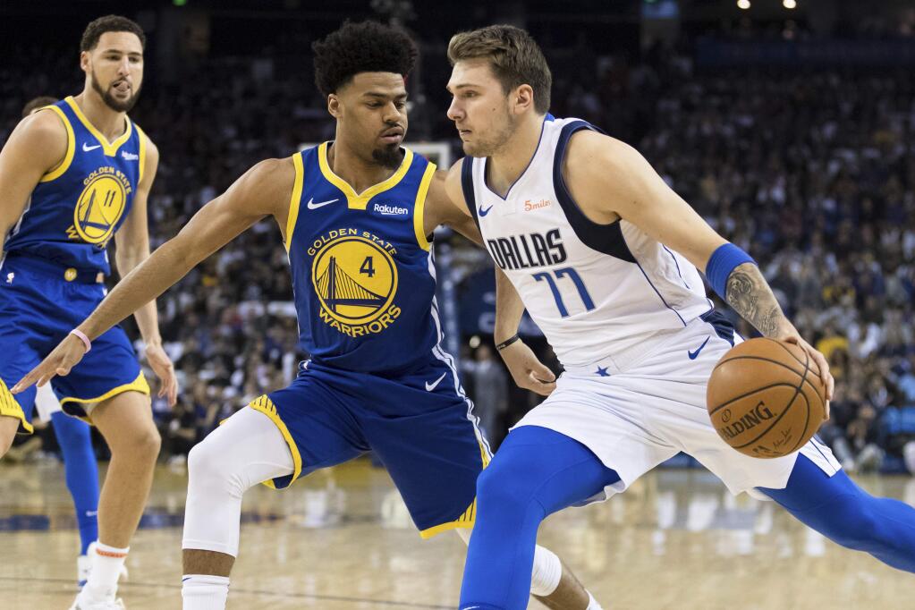 Dallas Mavericks forward Luka Doncic, right, dribbles as Golden State Warriors guard Quinn Cook (4) defends in the first half of an NBA basketball game Saturday, March 23, 2019, in Oakland, Calif. (AP Photo/John Hefti)