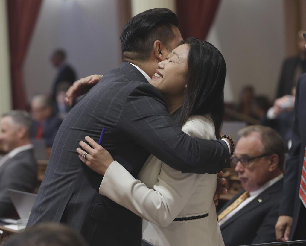FILE -- In this May 26, 2016 file photo Sen. Janet Nguyen, R-Fountain Valley, is congratulated by Sen. Richardo Lara, D-Bell Gardens, after the Senate approved one of her bills, in Sacramento, Calif. Lara, who was presiding over the Senate, ordered Nguyen removed from the floor Thursday, Feb. 23, 2017, after she refused to stop delivering a speech criticizing former Sen. Tom Hayden for his anti-war activism in Vietnam. (AP Photo/Rich Pedroncelli, File)