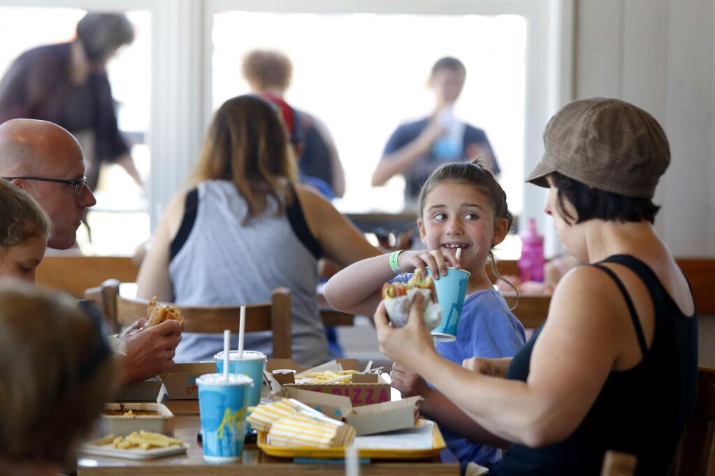 Maddie Curtis, 9, eats lunch with her mother, Jennifer, sister Sam, 10, far left, and father, Jared, at Amy's Drive Thru on Wednesday, June 29, 2016 in Rohnert Park, California . The family was visiting for a week from Boston and has eaten at the restaurant twice. (BETH SCHLANKER/ The Press Democrat)