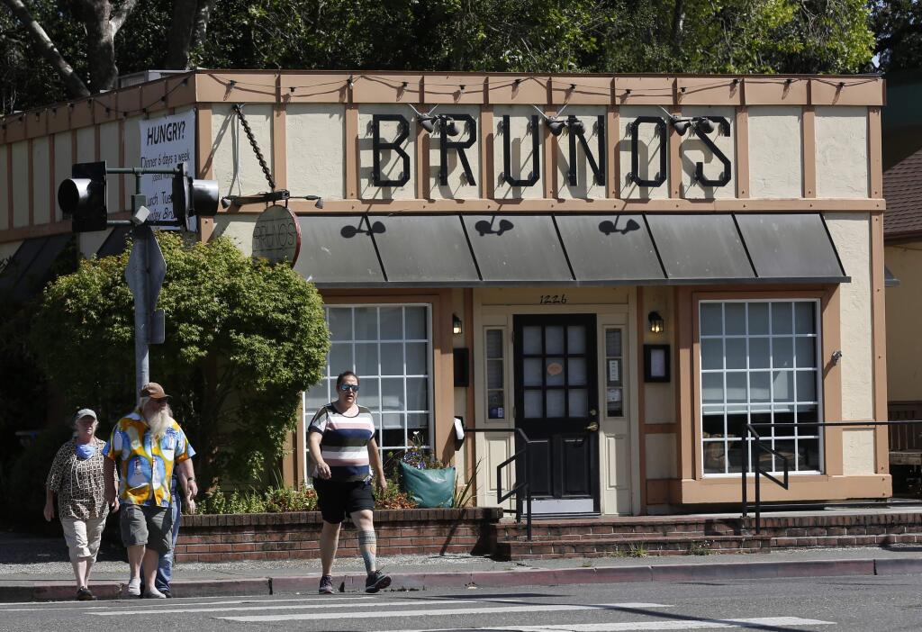 On June 14, 2020, pedestrians walks past Bruno's on Fourth restaurant, which is now permanently closed. (BETH SCHLANKER/ The Press Democrat)