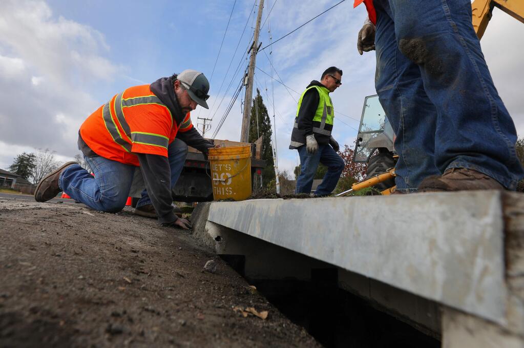 Town of Windsor employees Trevor Silva, left, and Lennie Morrell work on the repair and maintenance of a storm drain on the corner of Shiloh Road and Old Redwood Highway in Windsor on Tuesday, Jan. 14, 2020. (CHRISTOPHER CHUNG/PD)