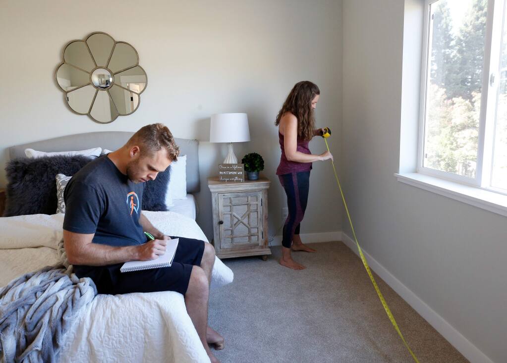 Fire survivors Julian and Lisa Corwin take measurements of the newly built house in which they are currently in escrow, to make sure the space will be suitable for their own furniture, in Santa Rosa, California, on Tuesday, September 17, 2019. (Alvin Jornada / The Press Democrat)