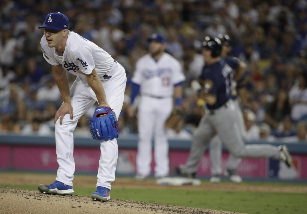 Los Angeles Dodgers starting pitcher Walker Buehler reacts after giving up a double to Milwaukee Brewers' Erik Kratz during the seventh inning of Game 3 of the National League Championship Series baseball game Monday, Oct. 15, 2018, in Los Angeles. (AP Photo/Jae Hong)