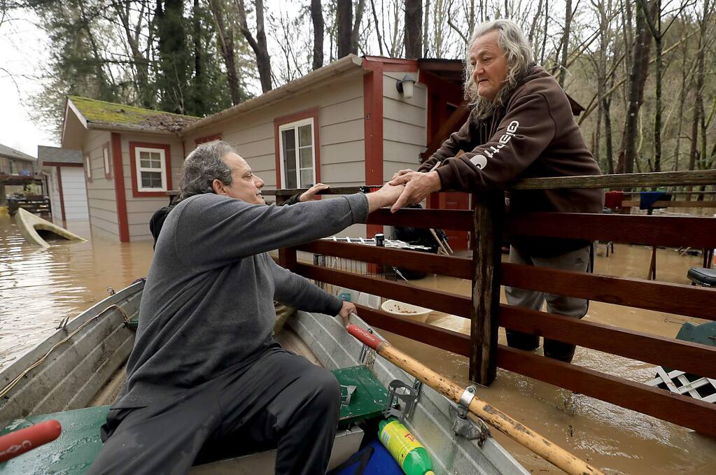 Jonathan Von Renner greets Jesse James at the Sycamore Court Apartments in Guerneville, Wednesday, Feb. 27, 2019. The night before, James moved to higher ground, only to find the water rose to cover the floor of the apartment. James was taken to dry land by the Russian River Fire swift water rescue team. (Kent Porter / The Press Democrat) 2019