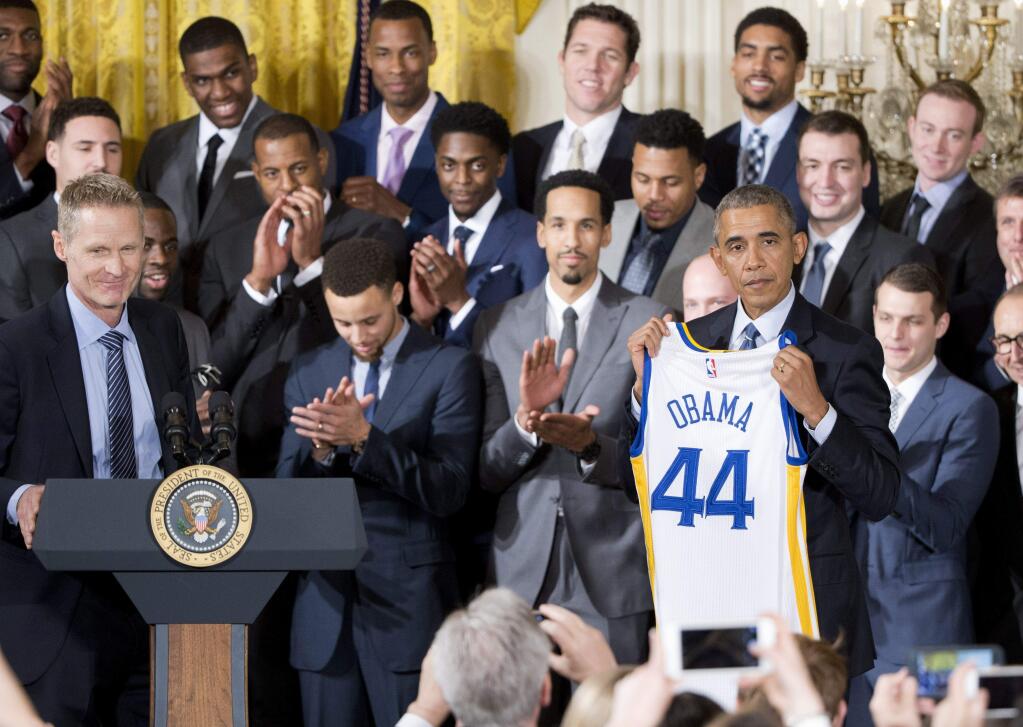 President Barack Obama hold up a Golden State Warrior basketball jersey presented to him by head coach Steve Kerr, left, during a ceremony in the East Room of the White House in Washington, Thursday, Feb. 4, 2016, where the president honored the 2015 NBA Champions. (AP Photo/Pablo Martinez Monsivais)