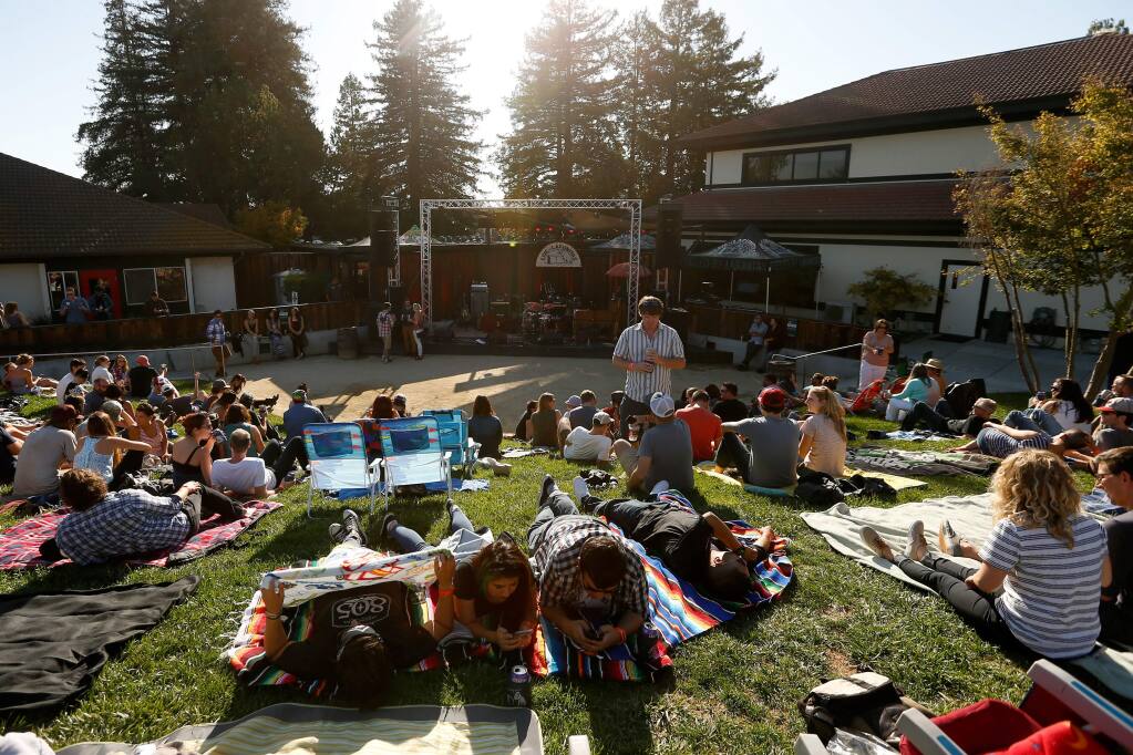 Visitors lounge on the lawn before the evening’s concert at Lagunitas Brewing Co. in Petaluma, Tuesday, Aug. 9, 2016. (Alvin Jornada / The Press Democrat file)