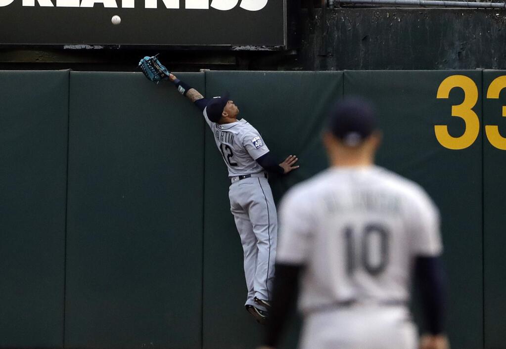 Seattle Mariners right fielder Leonys Martin leaps but can't catch a home run ball from the Oakland Athletics' Khris Davis during the first inning Tuesday, Aug. 8, 2017, in Oakland. (AP Photo/Marcio Jose Sanchez)