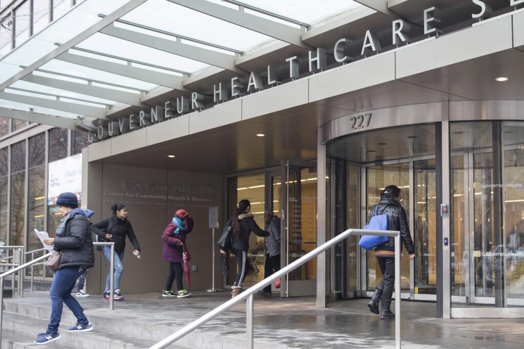 People enter New York City Health Hospitals Gouverneur Health building, Tuesday, Jan. 8, 2019, in New York. Mayor Bill de Blasio says New York City will spend up to $100 million per year to expand health care coverage to people without health insurance including immigrants in the U.S. illegally. (AP Photo/Mary Altaffer)
