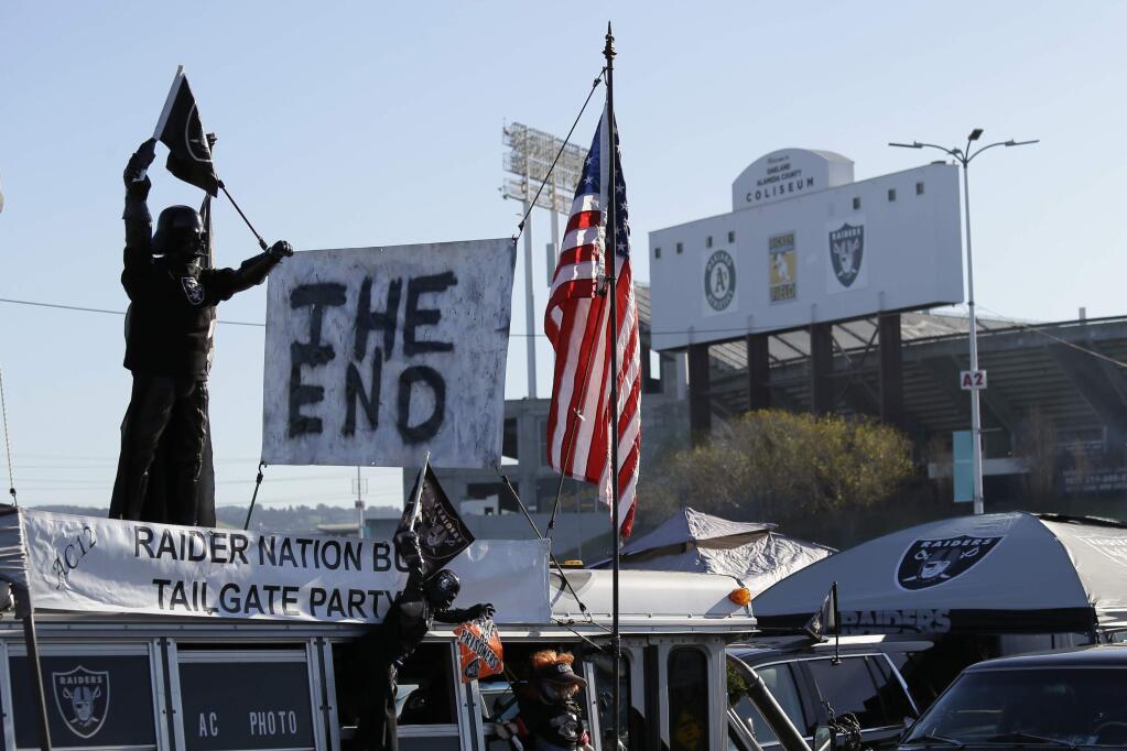 A sign reads 'The End' on top of the Raider Nation Bus before the start of an NFL football between the Oakland Raiders and the Jacksonville Jaguars game in Oakland, Calif., Sunday, Dec. 15, 2019. The game is the final scheduled Raiders game in Oakland. (AP Photo/Eric Risberg)