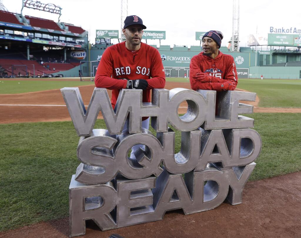 Boston Red Sox's J.D. Martinez, left, speaks with Boston Red Sox's Mookie Betts during batting practice for the World Series baseball game Monday, Oct. 22, 2018, in Boston. The Red Sox play the Los Angeles Dodgers in Game 1 on Tuesday, Oct. 23, 2018. (AP Photo/Elise Amendola)