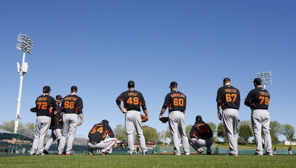 San Francisco Giants pitchers line up during situational base throwing drills during spring training baseball practice Wednesday, Feb. 25, 2015, in Scottsdale, Ariz. (AP Photo/Ross D. Franklin)