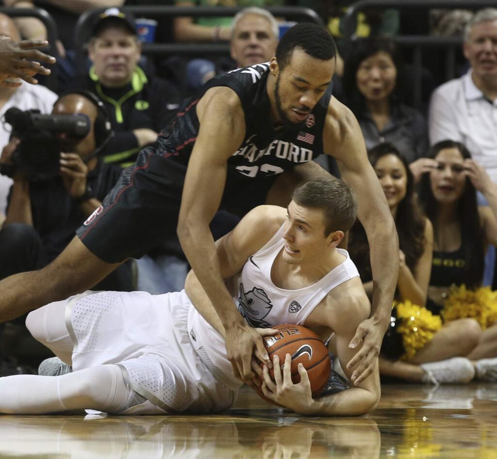 Stanford's Trevor Stanback, top, battles Oregon's Casey Benson for a loose ball during the first half Saturday, Jan. 21, 2017, in Eugene, Ore. (AP Photo/Chris Pietsch)