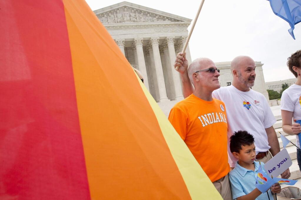 Rodney Moubray-Carrico of New Albany, Ind., left, his husband Scott Moubray-Carrico, who are among the Indiana plaintiff's, stand with their son Lucas, 7, outside of the Supreme Court in Washington, Friday June 26, 2015, before the court declared that same-sex couples have a right to marry anywhere in the US. (AP Photo/Jacquelyn Martin)