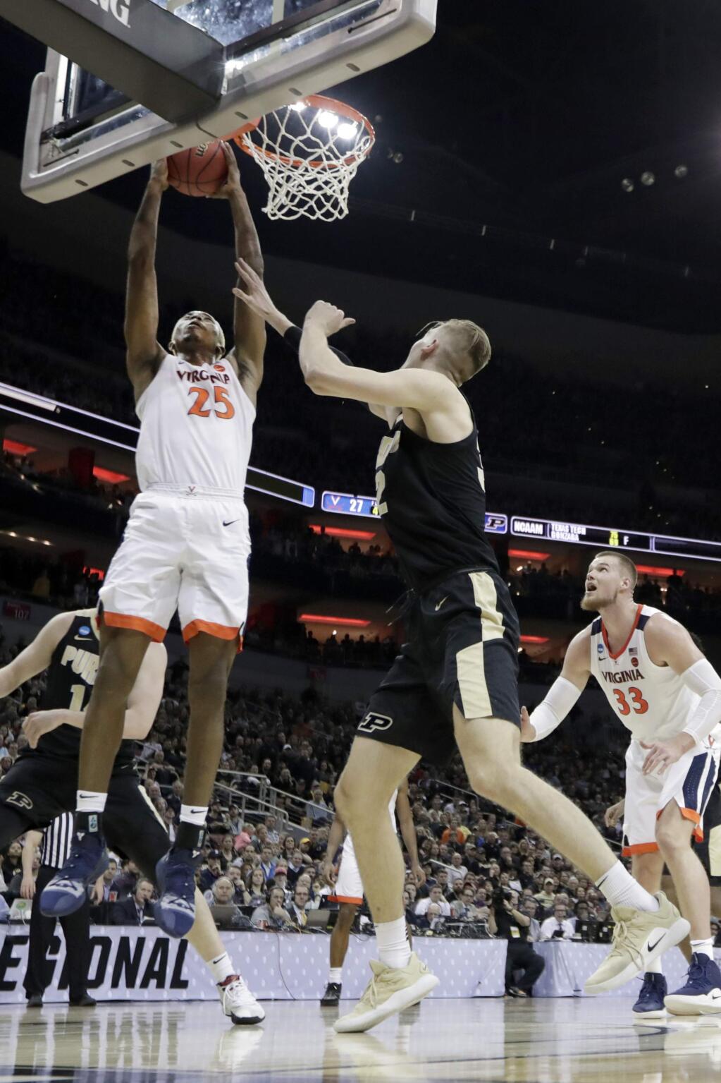 Virginia's Mamadi Diakite puts up a shot against Purdue's Matt Haarms, center, as Virginia's Jack Salt, right watches during the first half of the men's NCAA Tournament South Region final game, Saturday, March 30, 2019, in Louisville, Ky. (AP Photo/Michael Conroy)