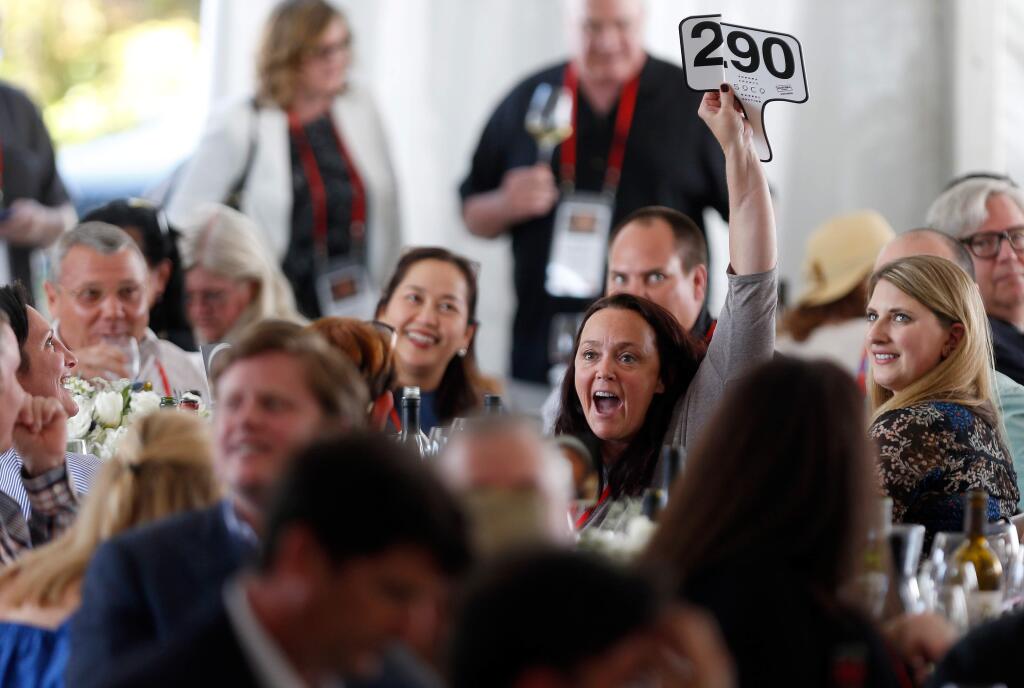 A broken paddle does not deter Shelby Peterson of C Lazy U Ranch in Colorado from winning a lot of Keller Estate Pinot Noir wine during the Sonoma County Barrel Auction at Vintner's Inn, in Santa Rosa, California, on Friday, April 21, 2017. (Alvin Jornada / The Press Democrat)